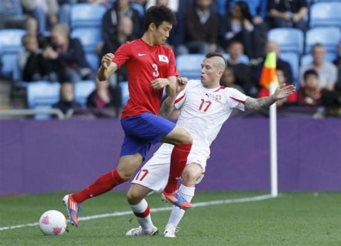 Yun Suk-young (trái) của Hàn Quốc tranh bóng với Michel Morganella (Thụy Sĩ).
